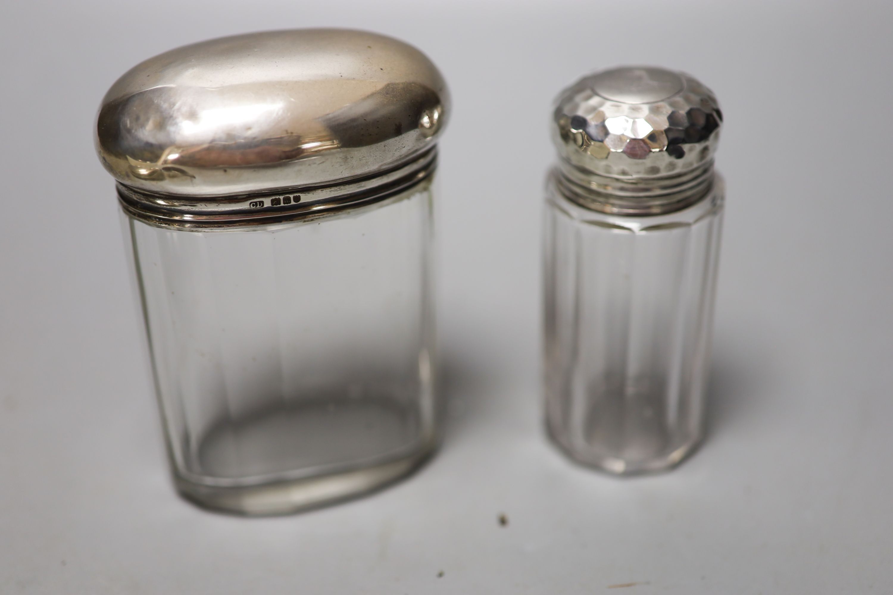 Six assorted silver mounted glass toilet jars, including a powder bowl and a Chinese white metal tot(a.f.).